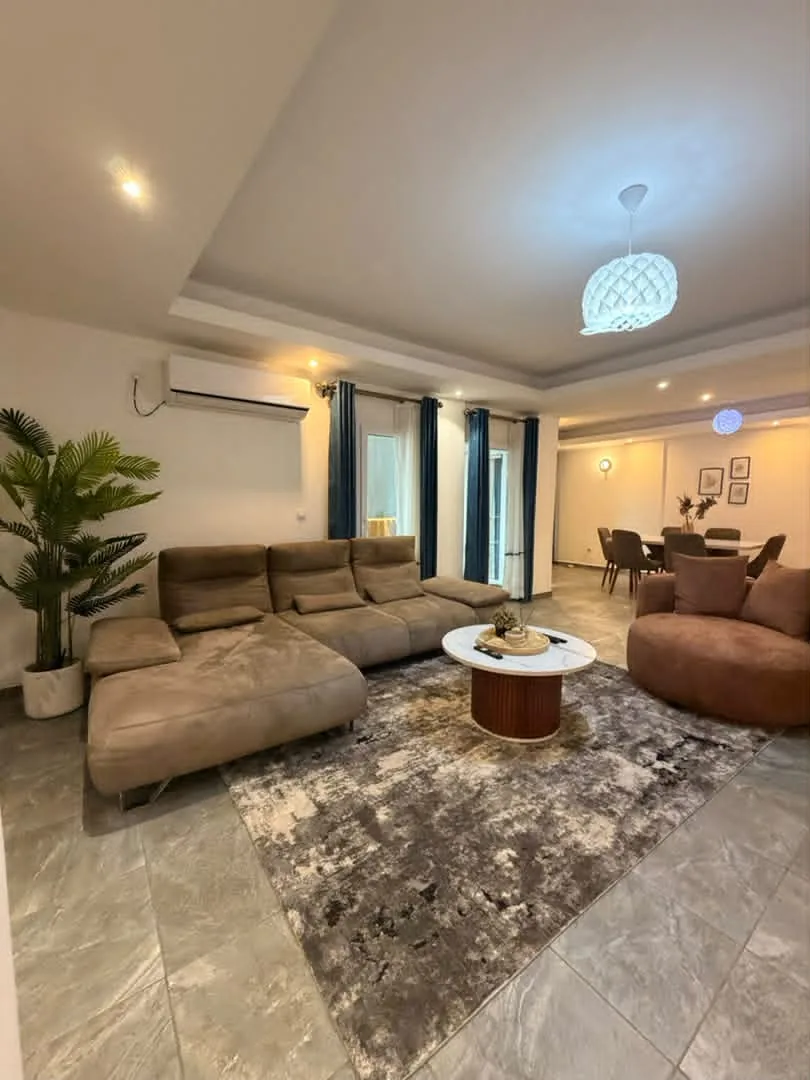 Salon de l'appartement à Bonanjo, Douala : canapé d'angle, fauteuil et coin repas