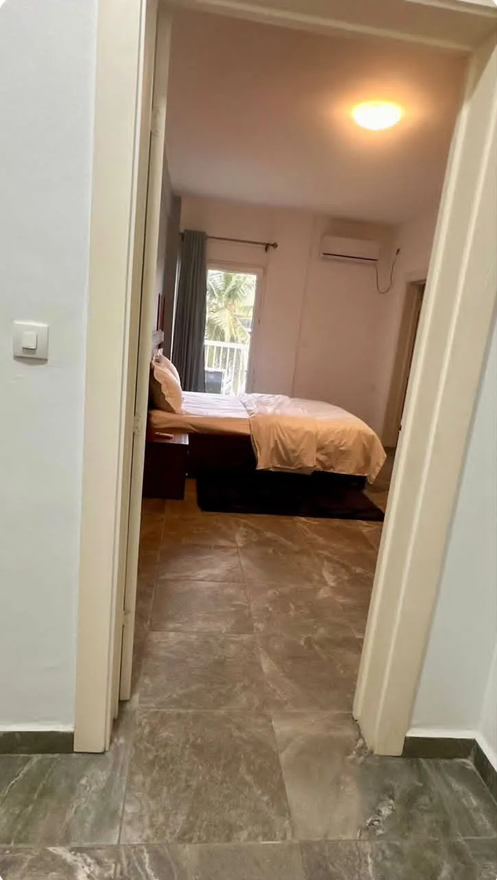 Chambre vue depuis la porte, avec climatiseur et porte-fenêtre