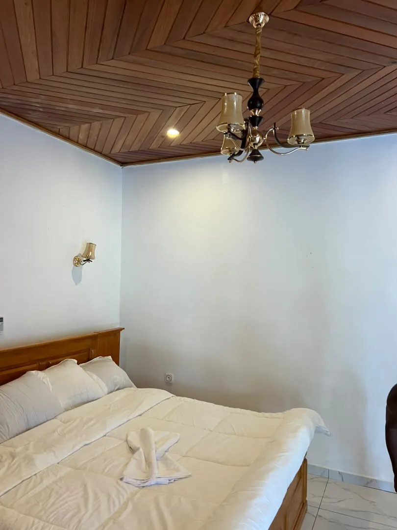 Chambre avec lit double et plafond en lambris de bois