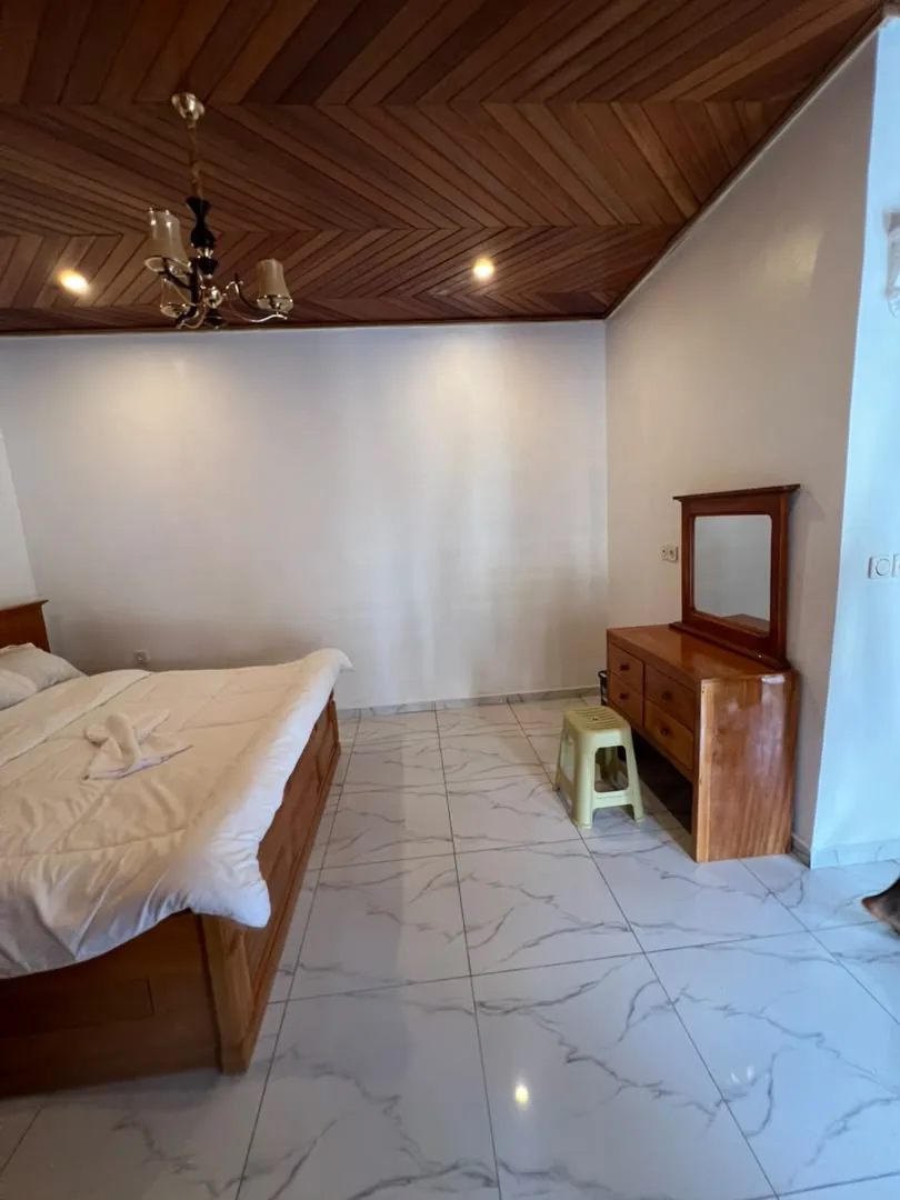Chambre avec lit double et coiffeuse en bois