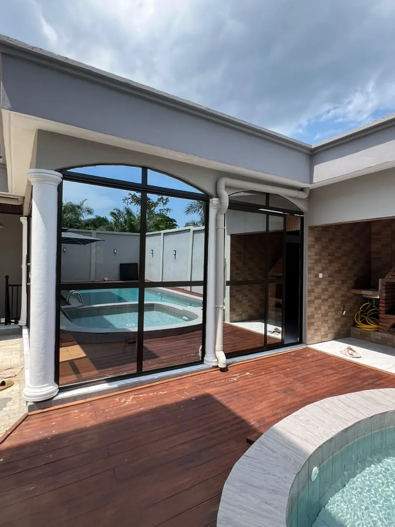 Terrasse en bois et baie vitrée donnant sur la piscine