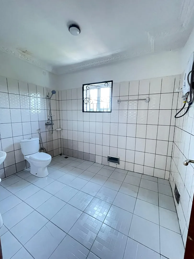 Salle d'eau carrelée avec douche et WC