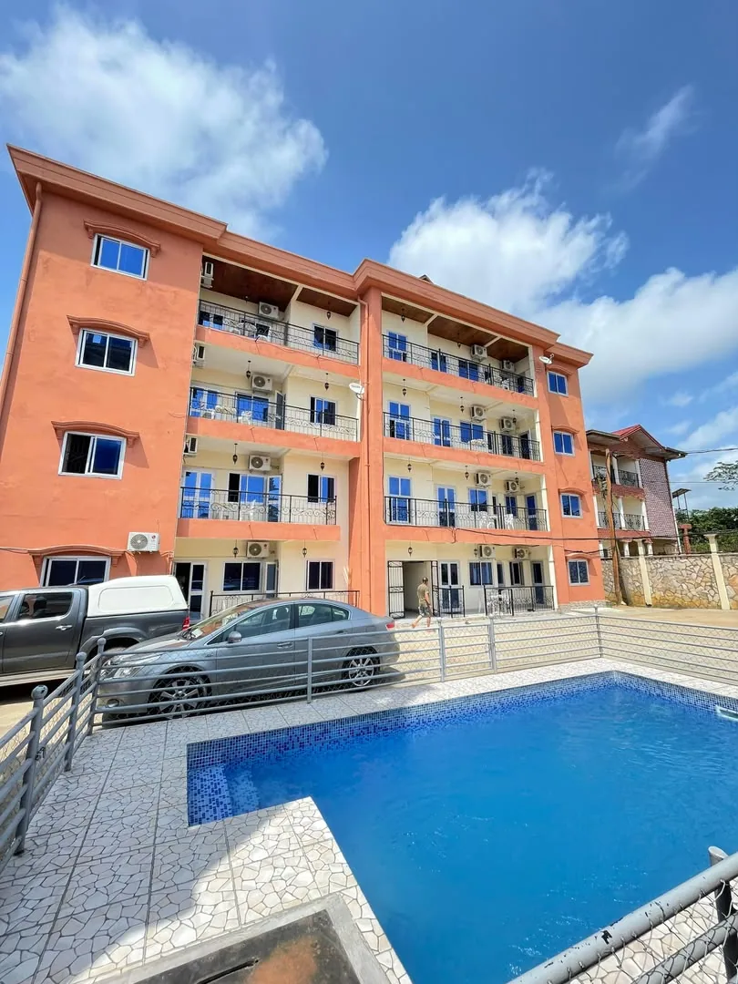 Piscine et immeuble de la résidence, voitures garées