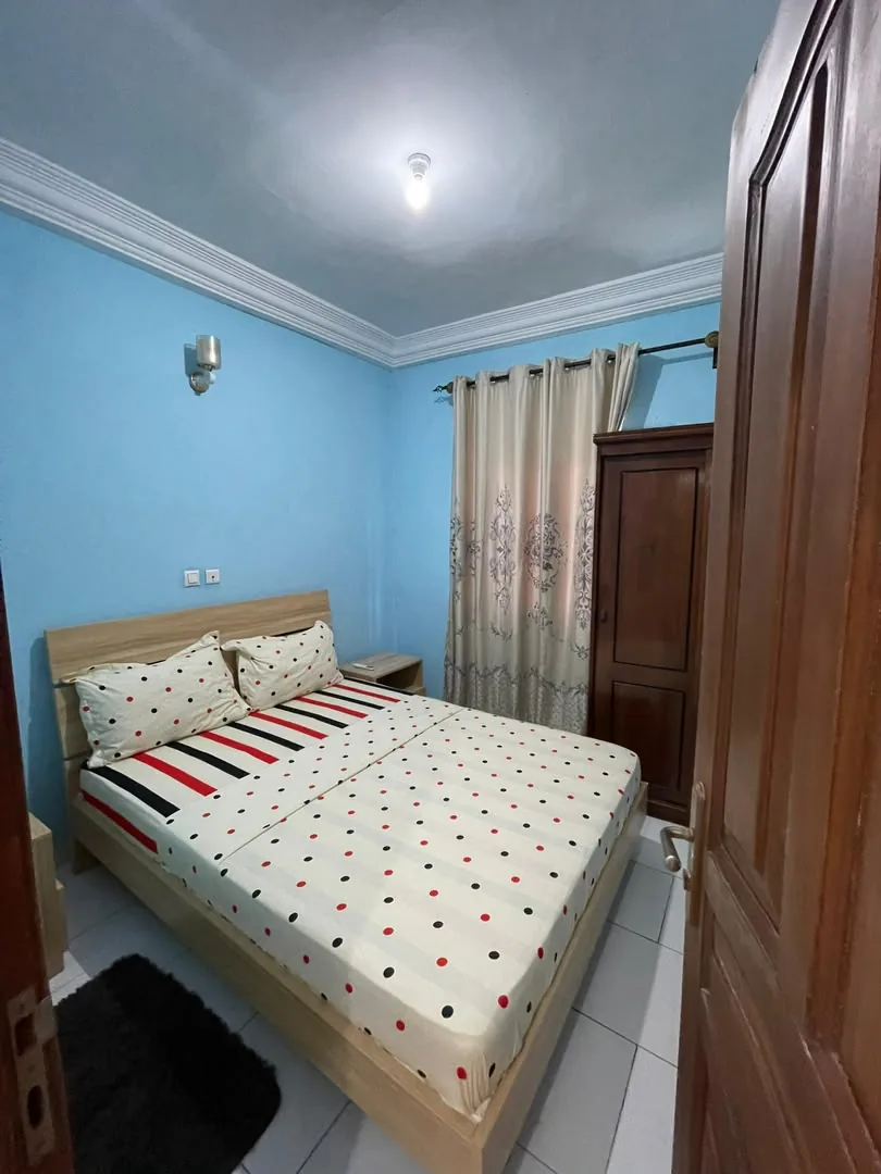 Chambre aux murs bleus, lit double et armoire