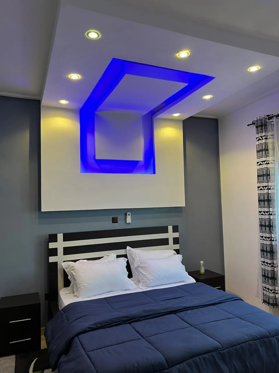 Chambre avec lit double et plafond éclairé en bleu